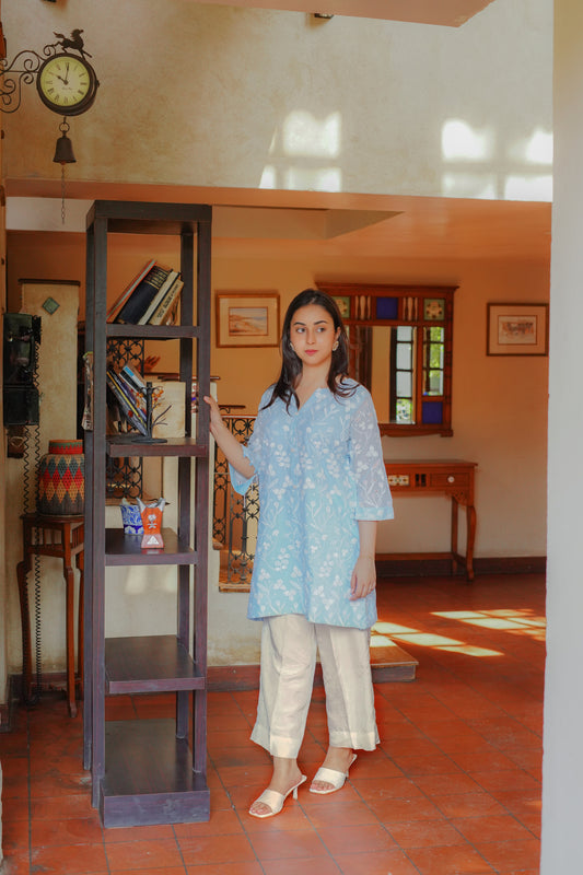 Light blue embroidered tunic with floral patterns for women – paired with cream-colored pants and heels. Perfect for casual and semi-formal occasions. Shop elegant and modest women's clothing online.