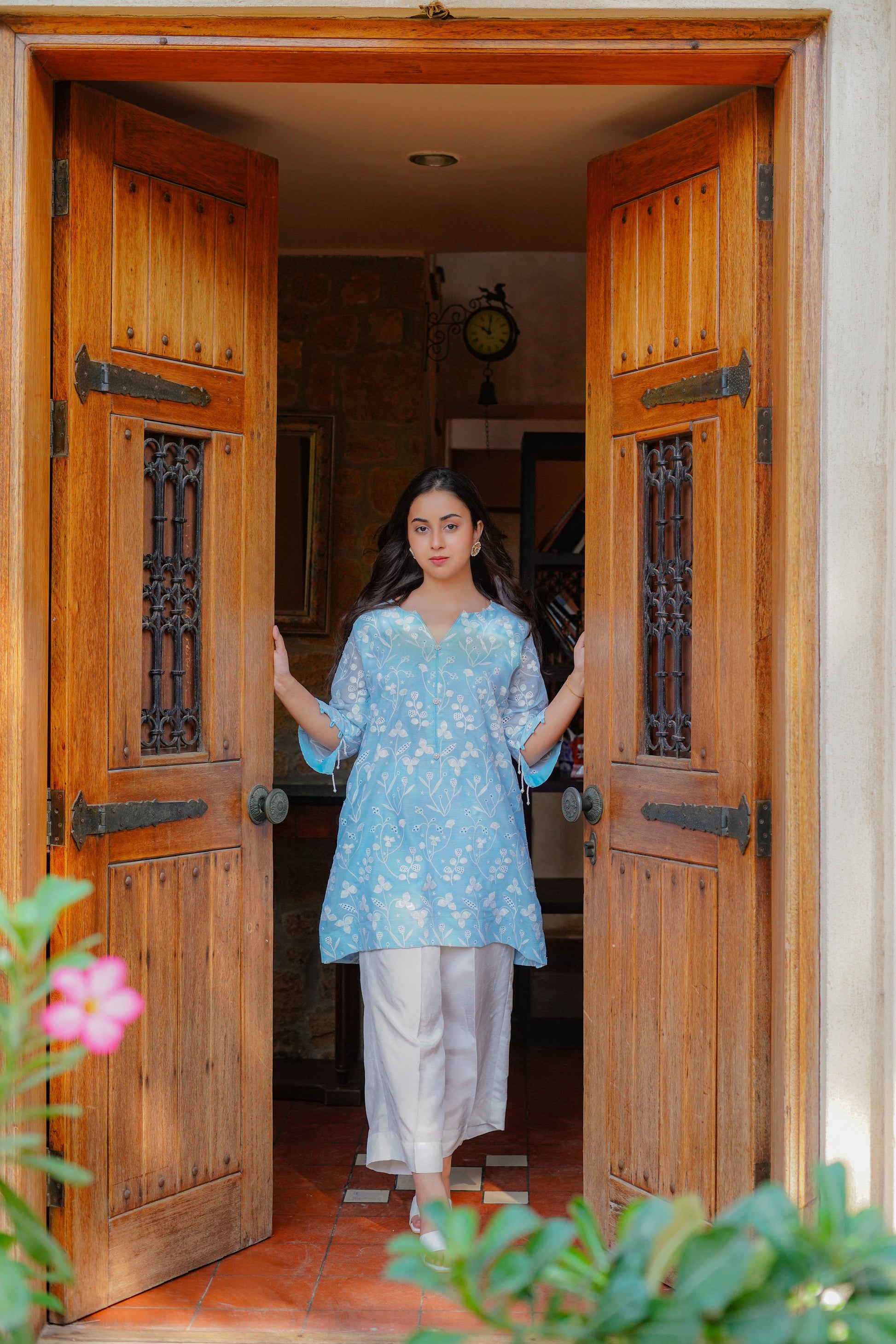 Light blue embroidered tunic with floral patterns for women – paired with cream-colored pants and heels. Perfect for casual and semi-formal occasions. Shop elegant and modest women's clothing online.