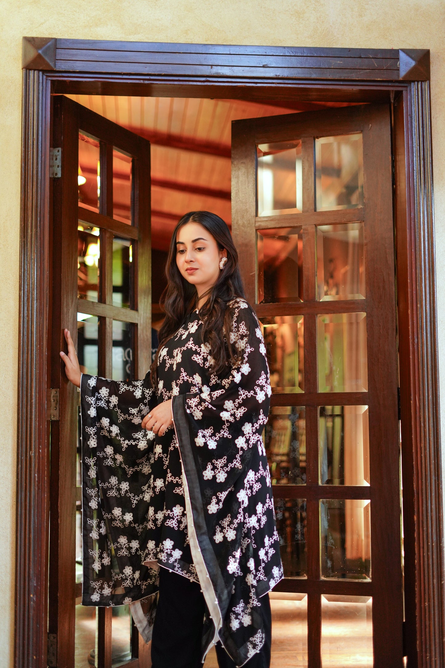 Elegant black and white printed cape-style tunic for women – paired with black pants and white heels. Ideal for modern, modest, and chic looks. Shop stylish women's outfits online.