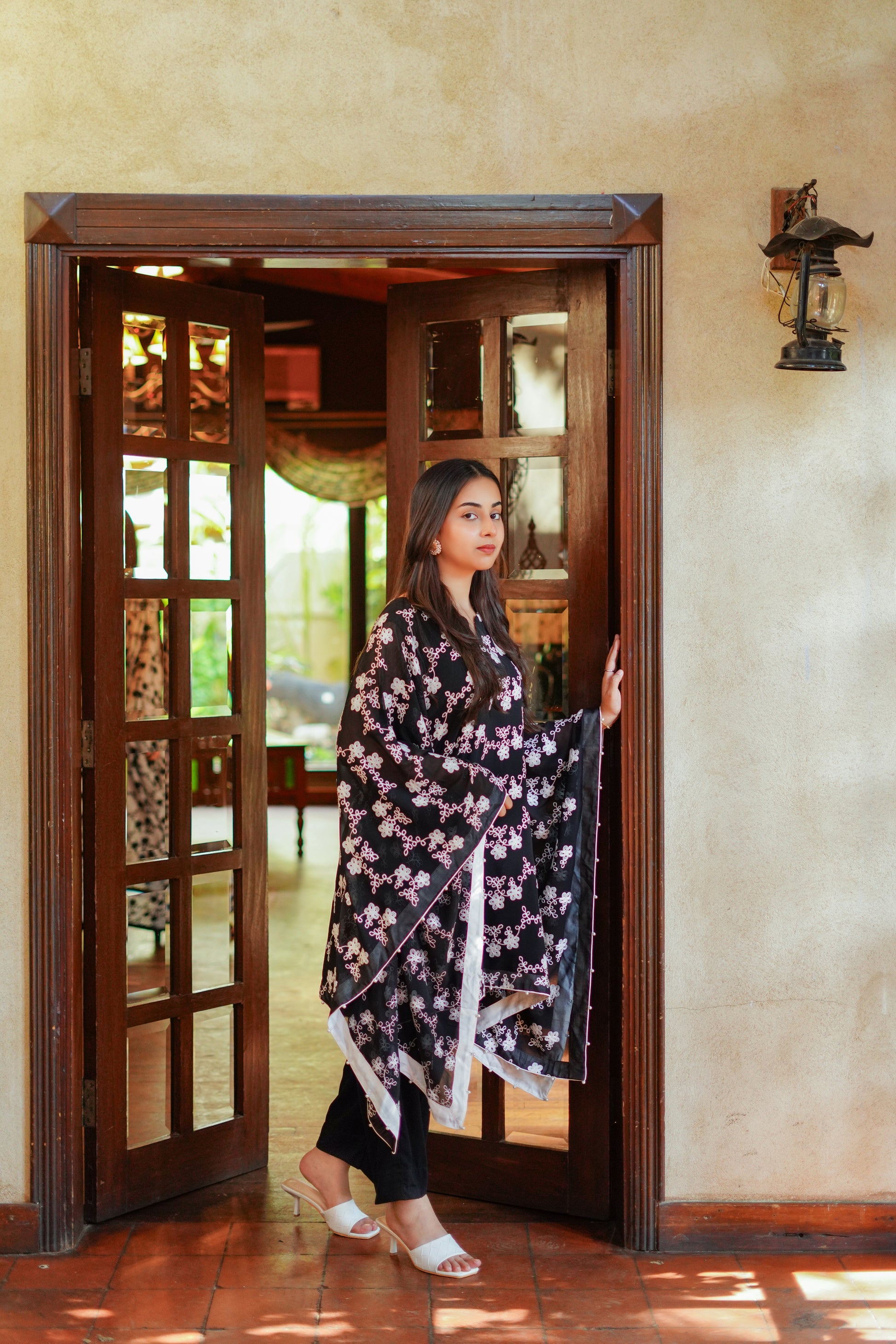 Elegant black and white printed cape-style tunic for women – paired with black pants and white heels. Ideal for modern, modest, and chic looks. Shop stylish women's outfits online.